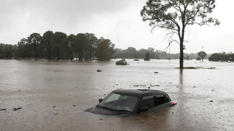 A partially submerged car is seen abando<em></em>ned in floodwaters in the suburb of Windsor as the state of New South Wales